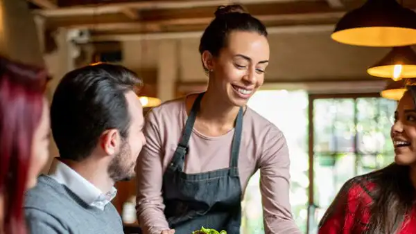 Lady serving a table of happy folks