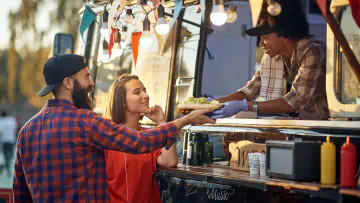 Food truck serves meal to two patrons